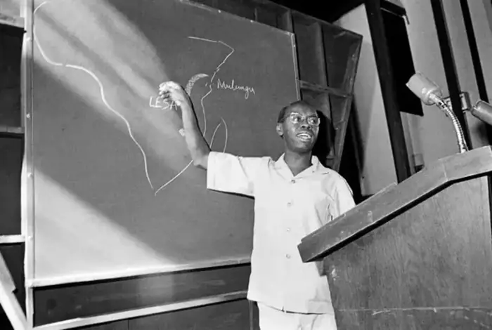 Archival photograph of a man at a chalkboard