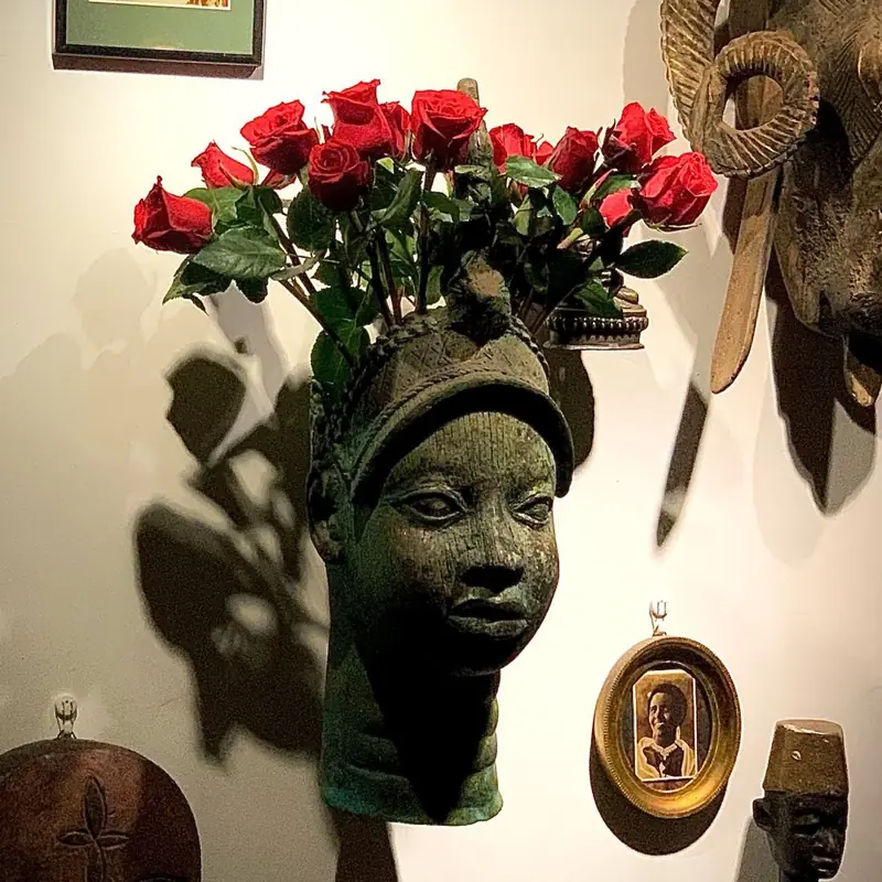A bronze head crowned with red roses
