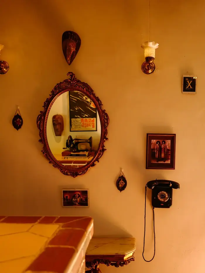 An ornate mirror, masks and a rotary telephone